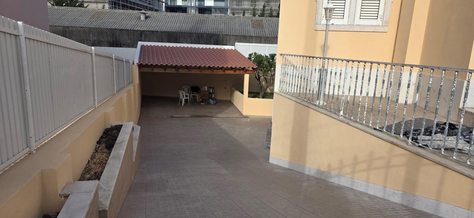 Pátio coberto e alpendre com telhado em telha e paredes recuperadas em cor pêssego, após remodelação exterior
